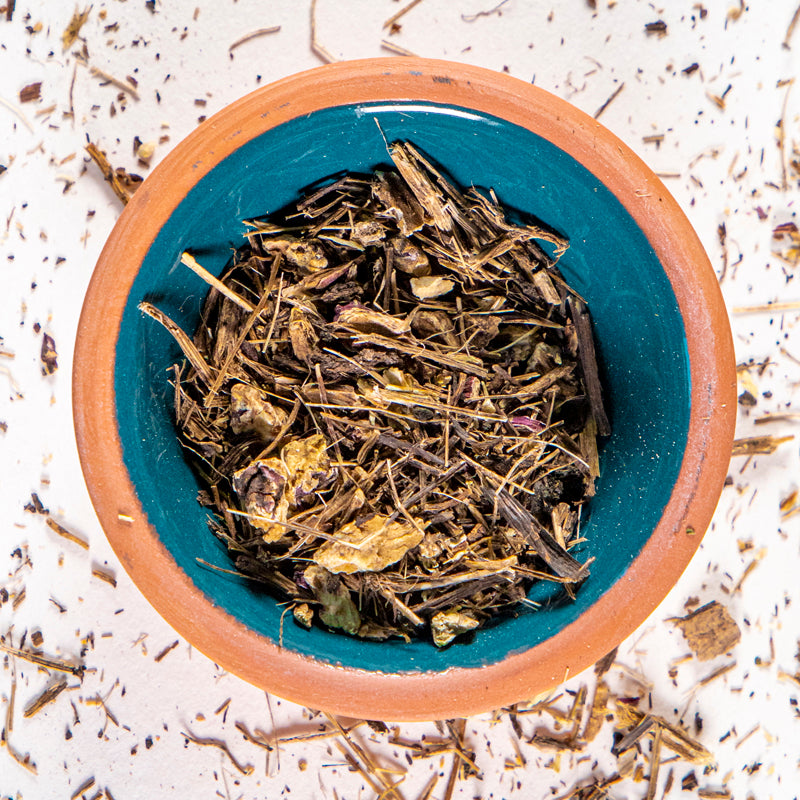 Echinacea Root herb in blue clay bowl with white background and herb surrounding.