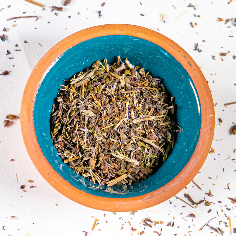Eyebright herb in blue clay bowl with white background and herb surrounding.